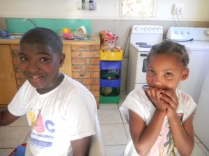 Elemenatary age boy and girl orphans in front of the washing machine in the orphanage for AIDS victims in South Africa.