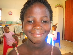 Close up photo of preteen girl orphan in kitchen at ghetto orphanage for HIV victims.  The girl is beautiful and appears in good health.