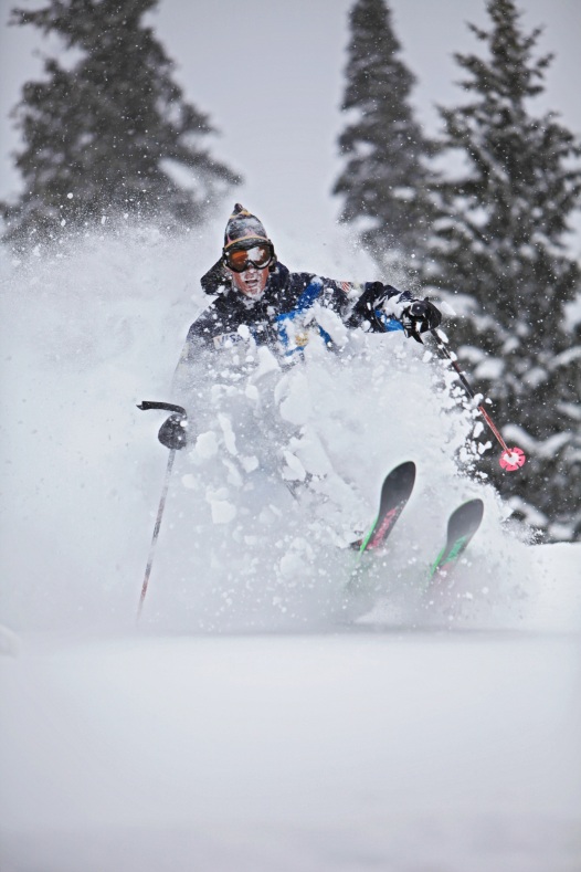 Male powder skier with ski tips up and snow powder waist high